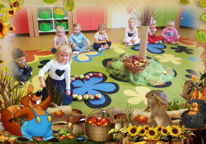 Dzieci siedzą na dywanie, patrzą na ułożone jabłka.